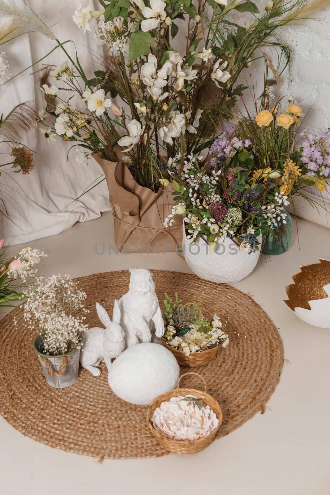 Interior floral Easter composition. Figurines of Easter bunnies and a large eggshell. The concept of home decoration for the Happy Easter holiday