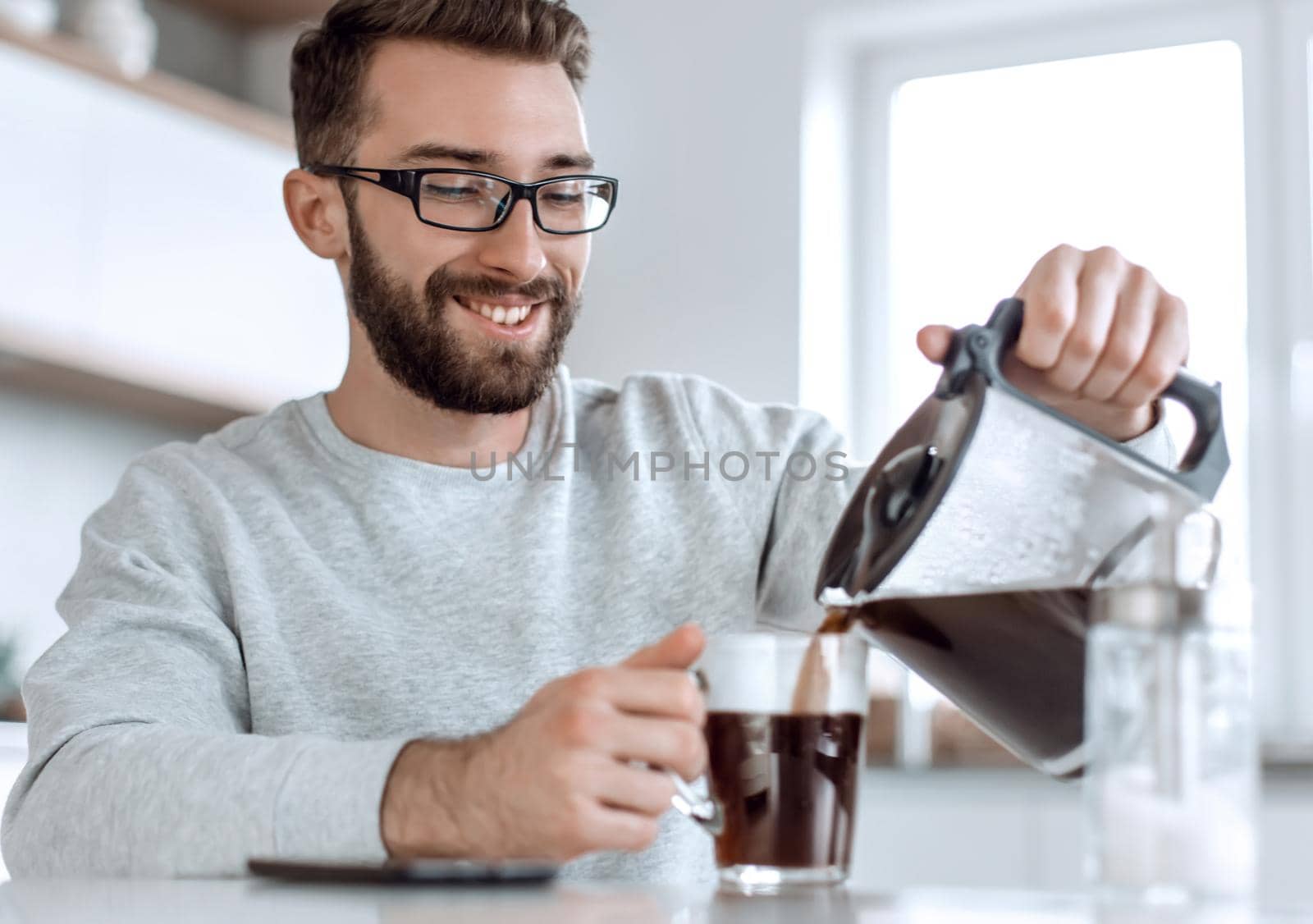 close up. attractive man pouring himself a Cup of morning coffee