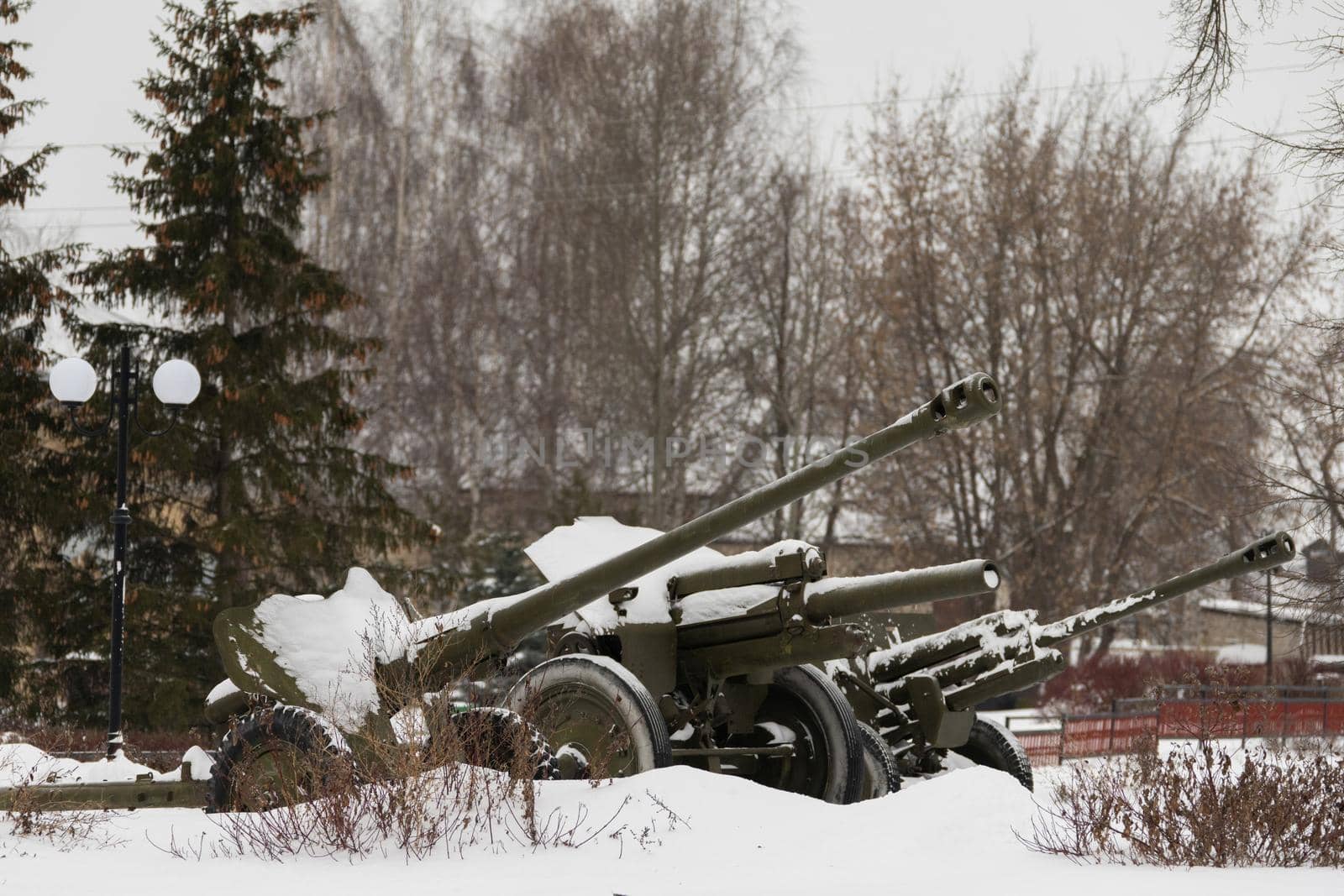 artillery pieces from the Second World War stand near the monument to the heroes of the war. Russia remembers the victims. In winter they were covered with snow