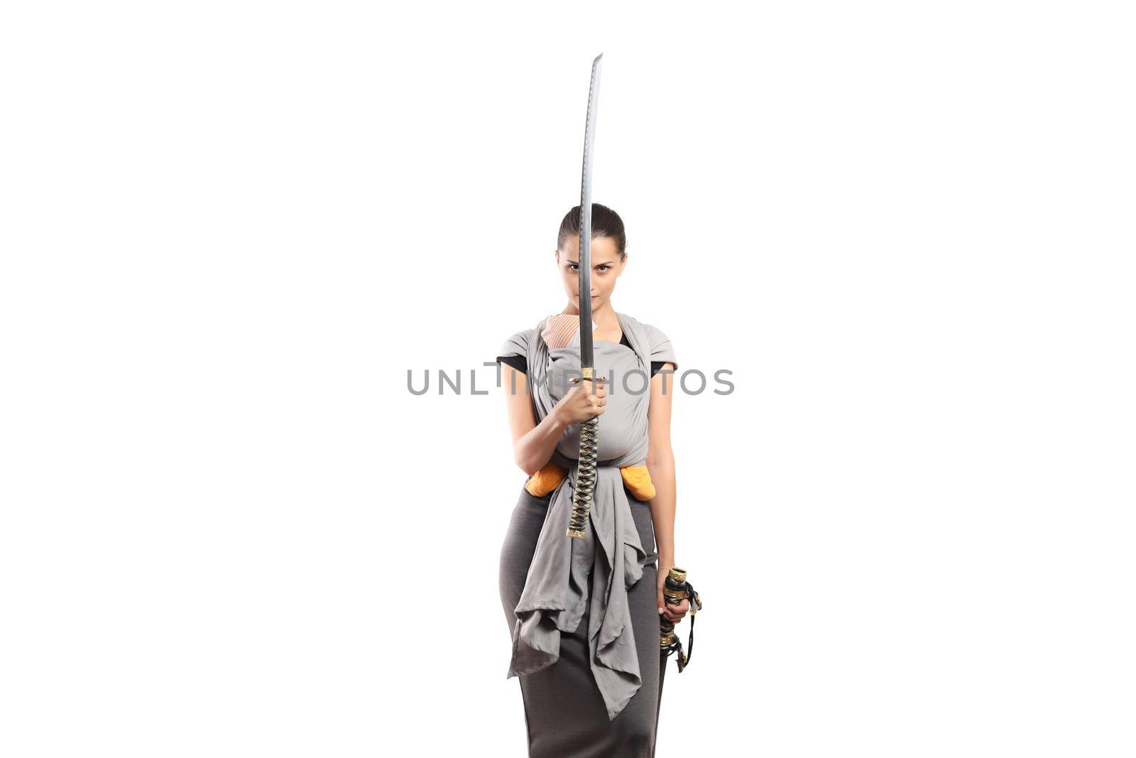 Babywearing attractive young mother with baby in carrier. Holding a japanese sword. mother protection concept.