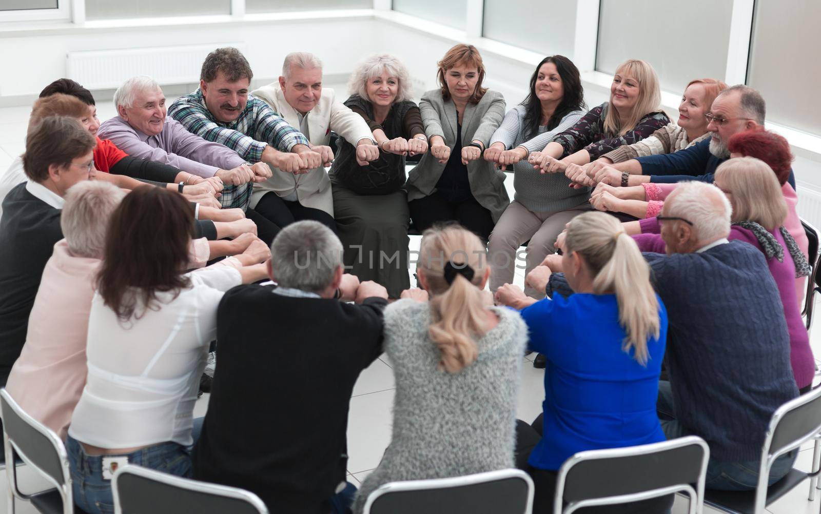 a group of mature mature people stretched their arms forward sit by asdf