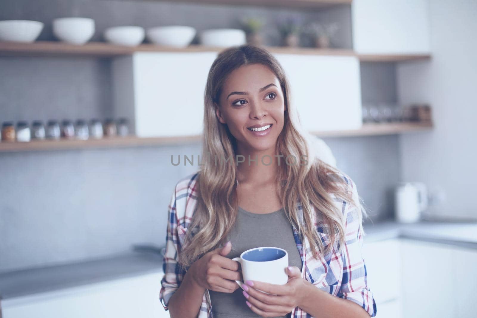 close up. cute young woman with mug standing in kitchen