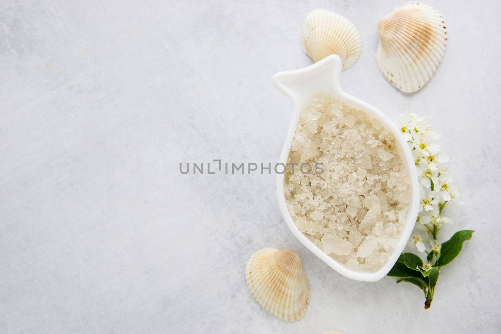 Concept of Spa-cosmetic and cosmetic procedures. Spa-sea salt in white dishes and seashells on light concrete background. The concept of a waste-free lifestyle. copyspase flatlay.