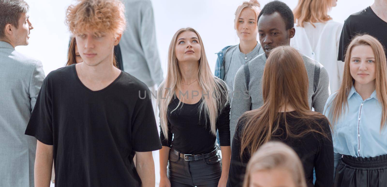 serious woman standing in front of casual group of young people by asdf