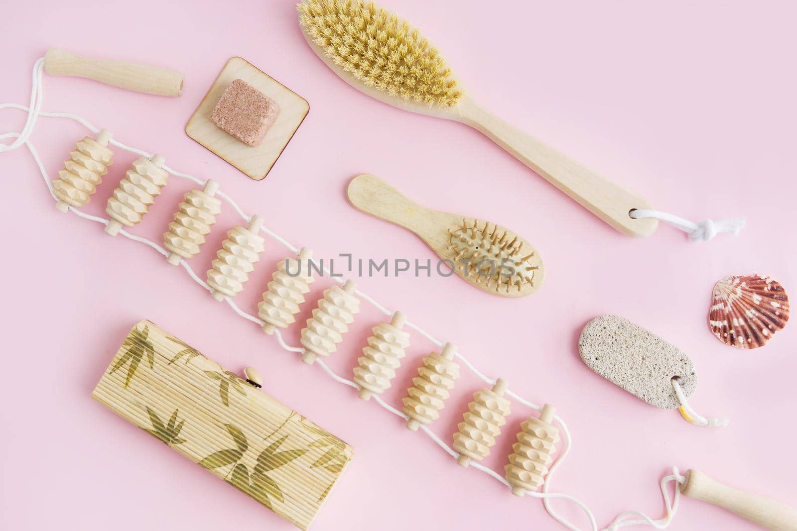 Concept of Spa-cosmetic and cosmetic procedures. Spa-sea salt, wooden comb, massager, Penza, anti-cellulite massage brush on a pink background. The concept of a waste-free lifestyle.