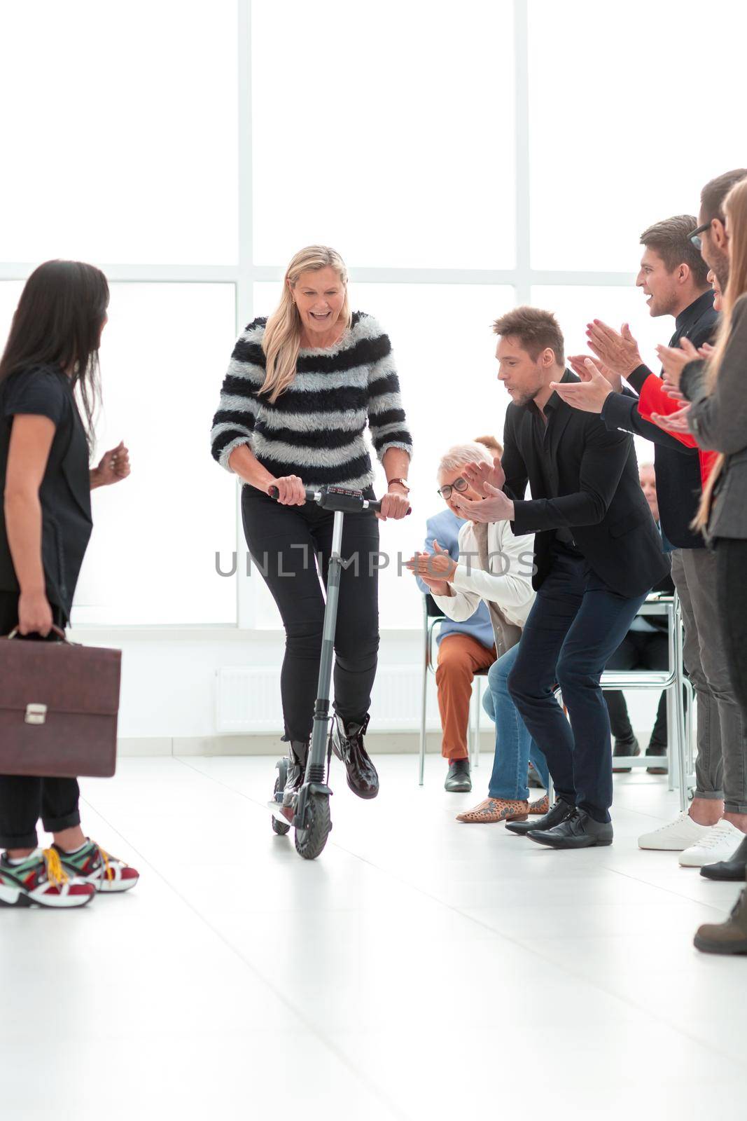 business woman on a scooter in the office in her free time by asdf