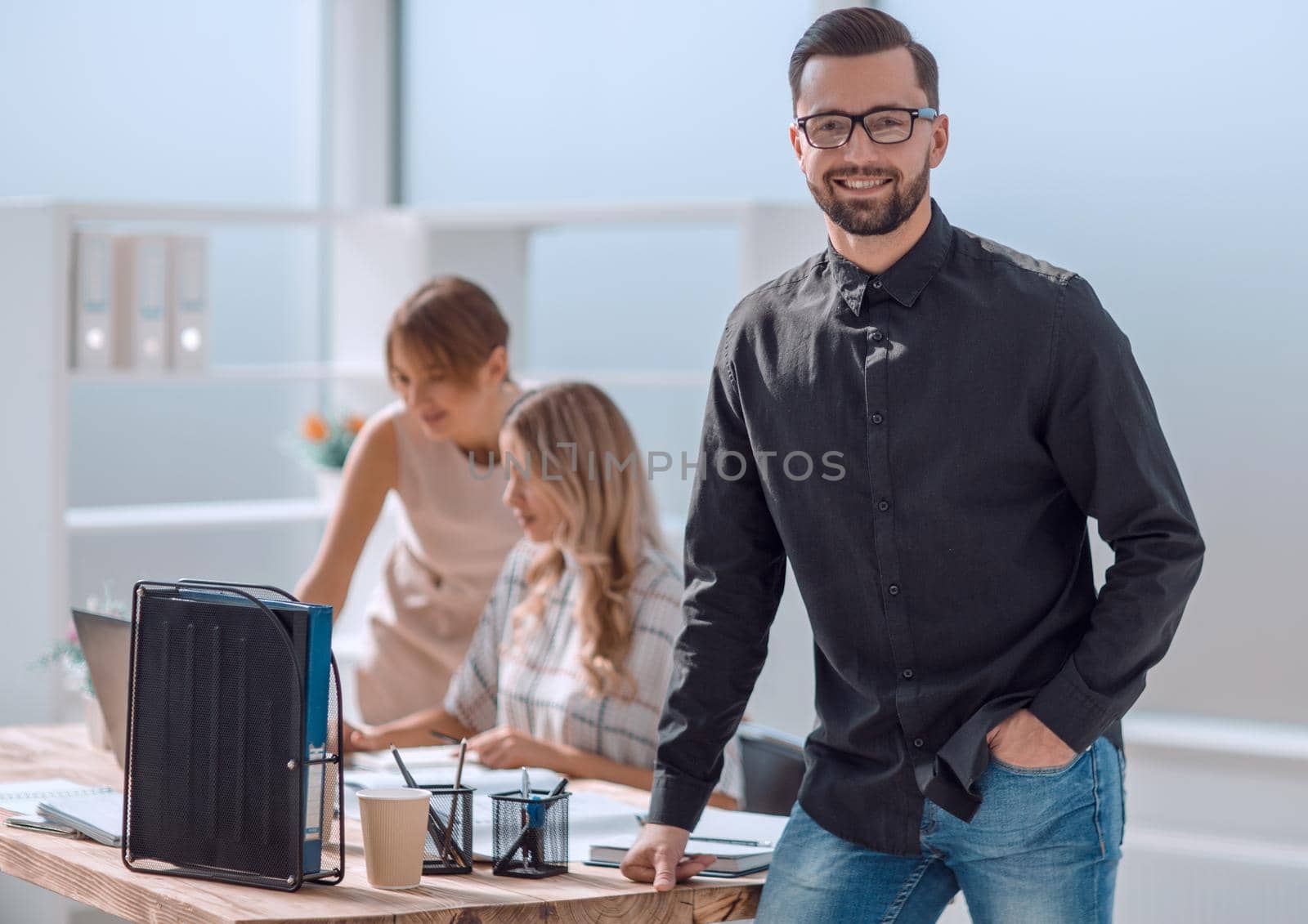 smiling young business man standing in office by asdf