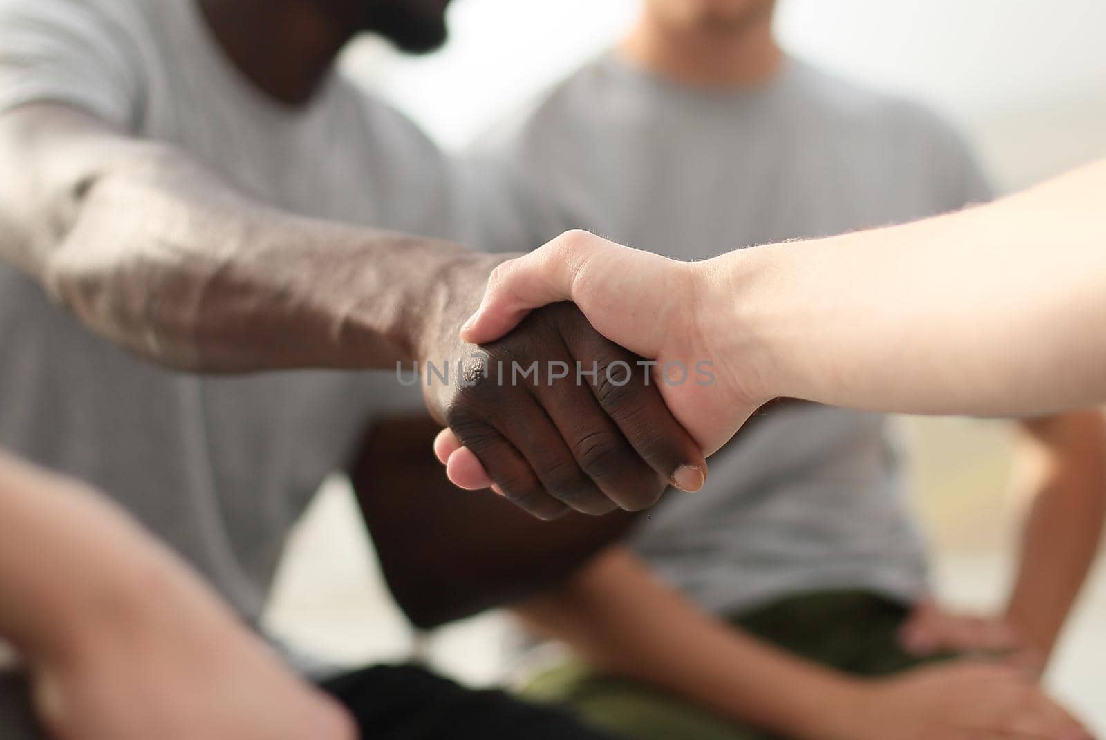 close up. smiling guy shaking hands with his friend. photo with space for text