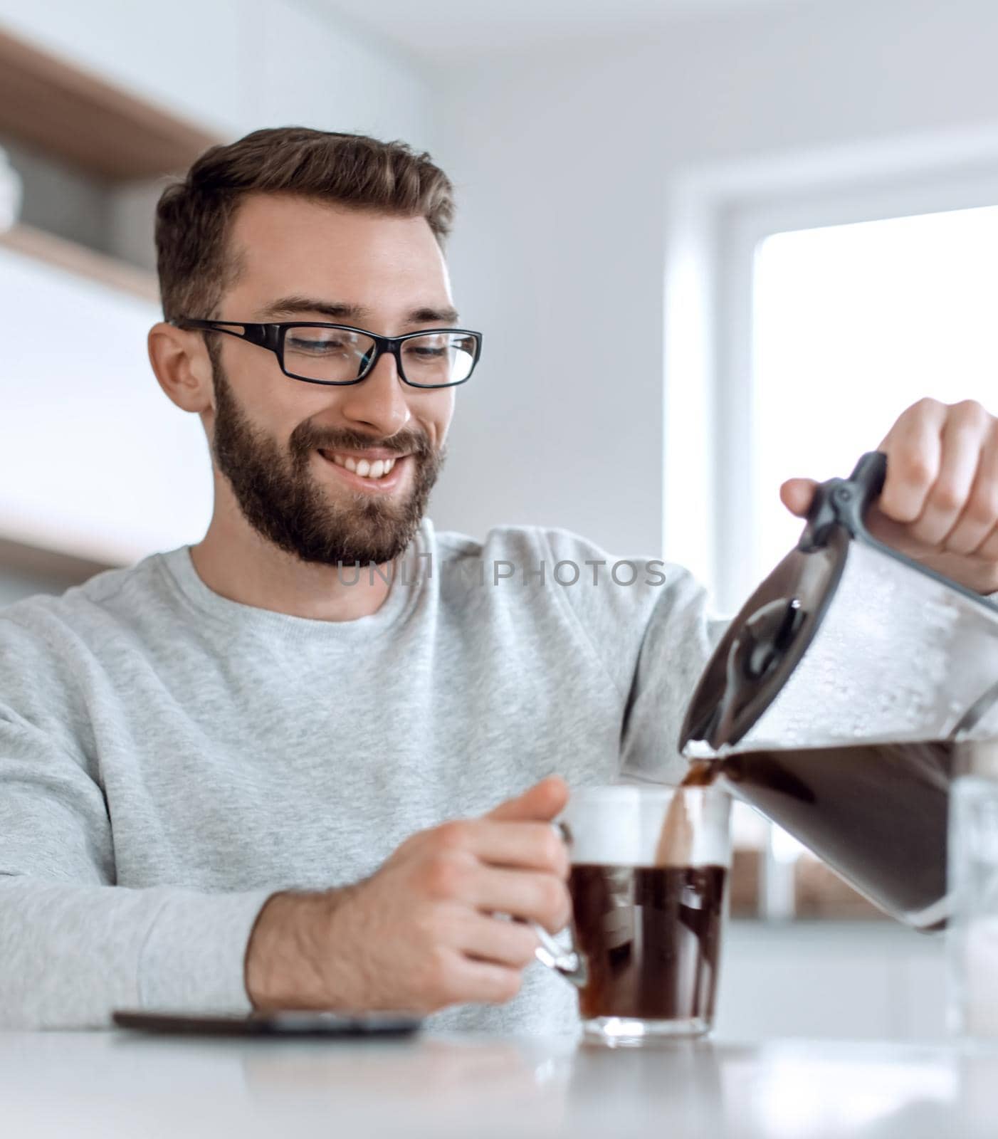 close up. attractive man pouring himself a Cup of morning coffee