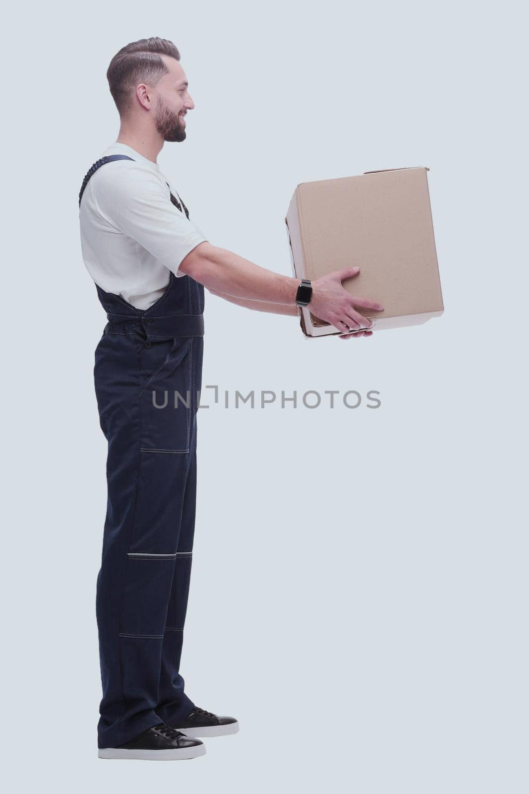 side view. smiling man passing a cardboard box . photo with copy space