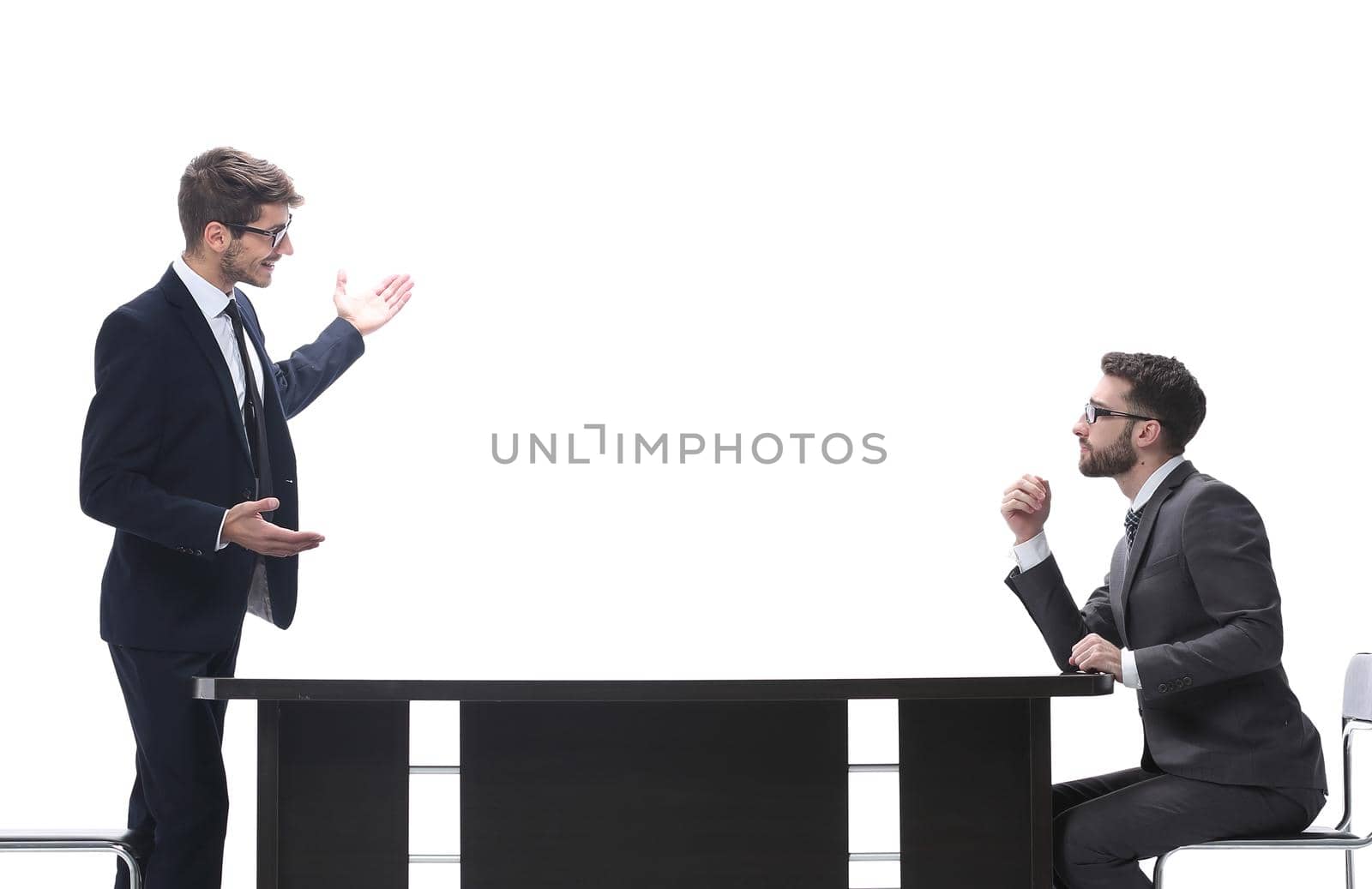 side view. business colleagues discussing something near the desktop . isolated on white