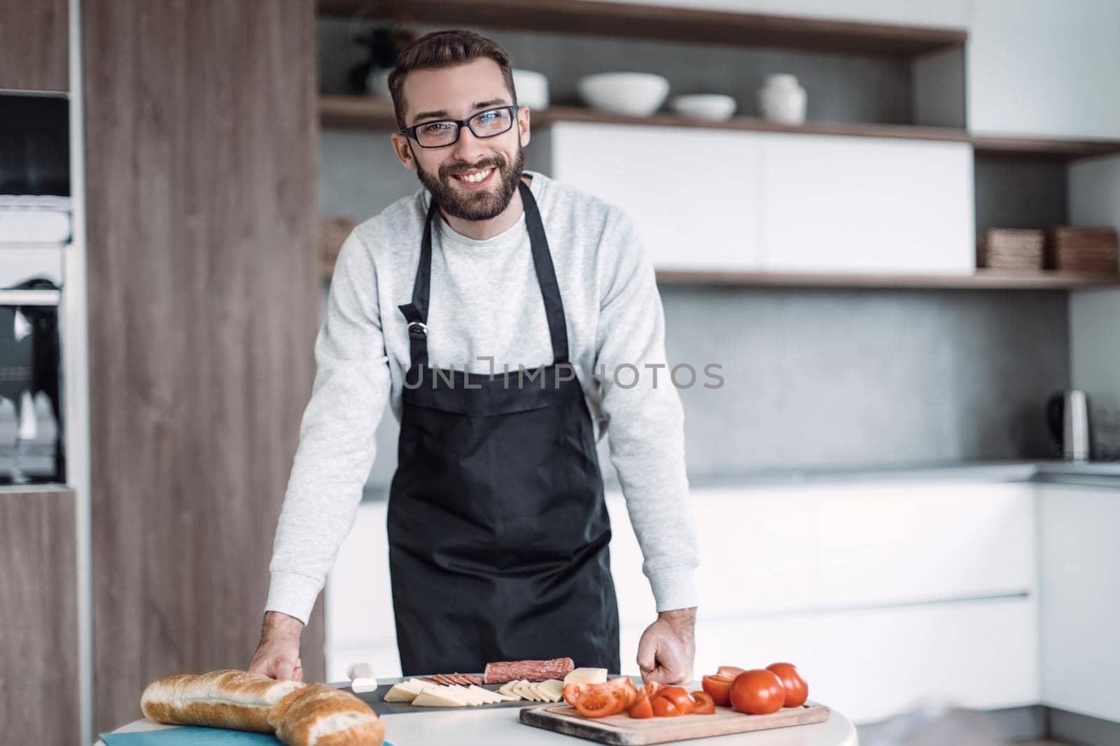 close up. a man in an apron slicing salami for sandwiches
