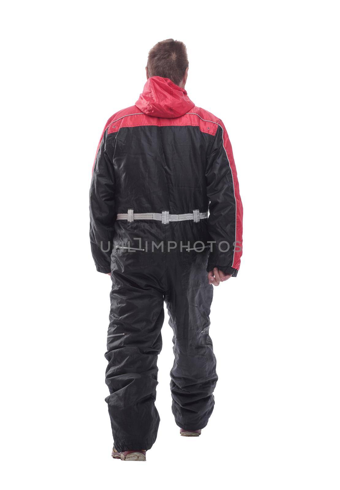 in full growth. a man in a winter insulated jumpsuit reading walking forward . isolated on a white background