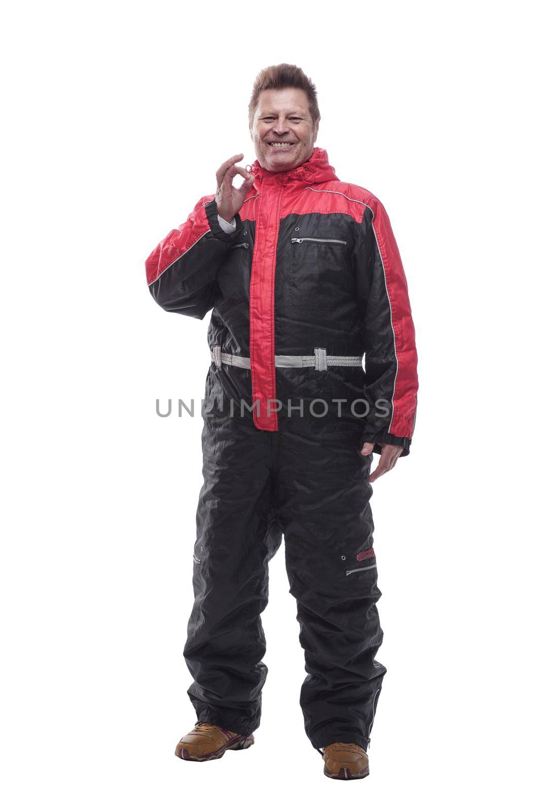 in full growth. a man in a winter insulated jumpsuit reading walking forward . isolated on a white background