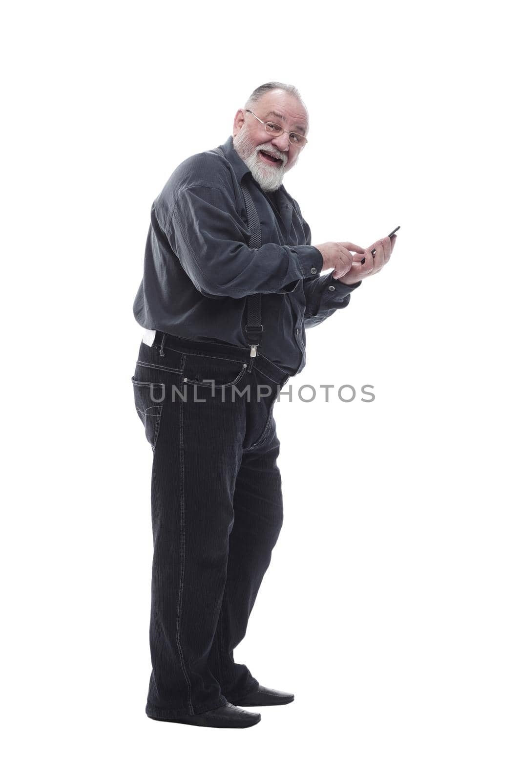 side view. smiling elderly man typing on his smartphone isolated on a white background.