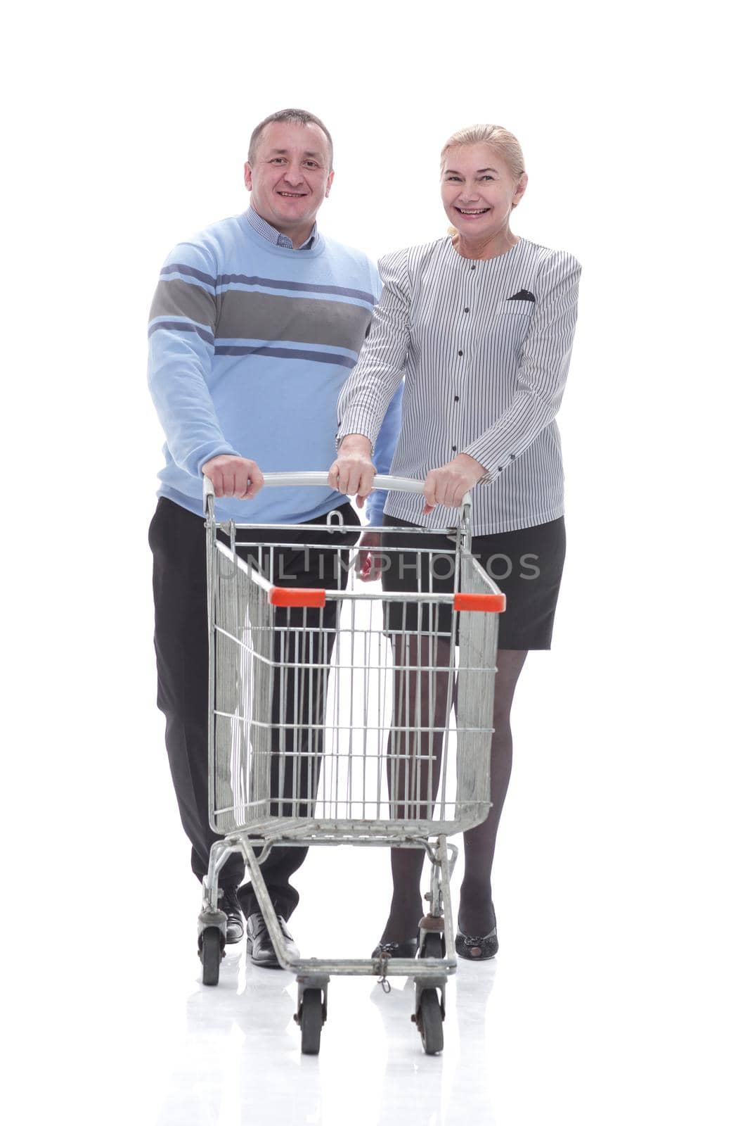 in full growth. casual couple with shopping cart . isolated on a white background