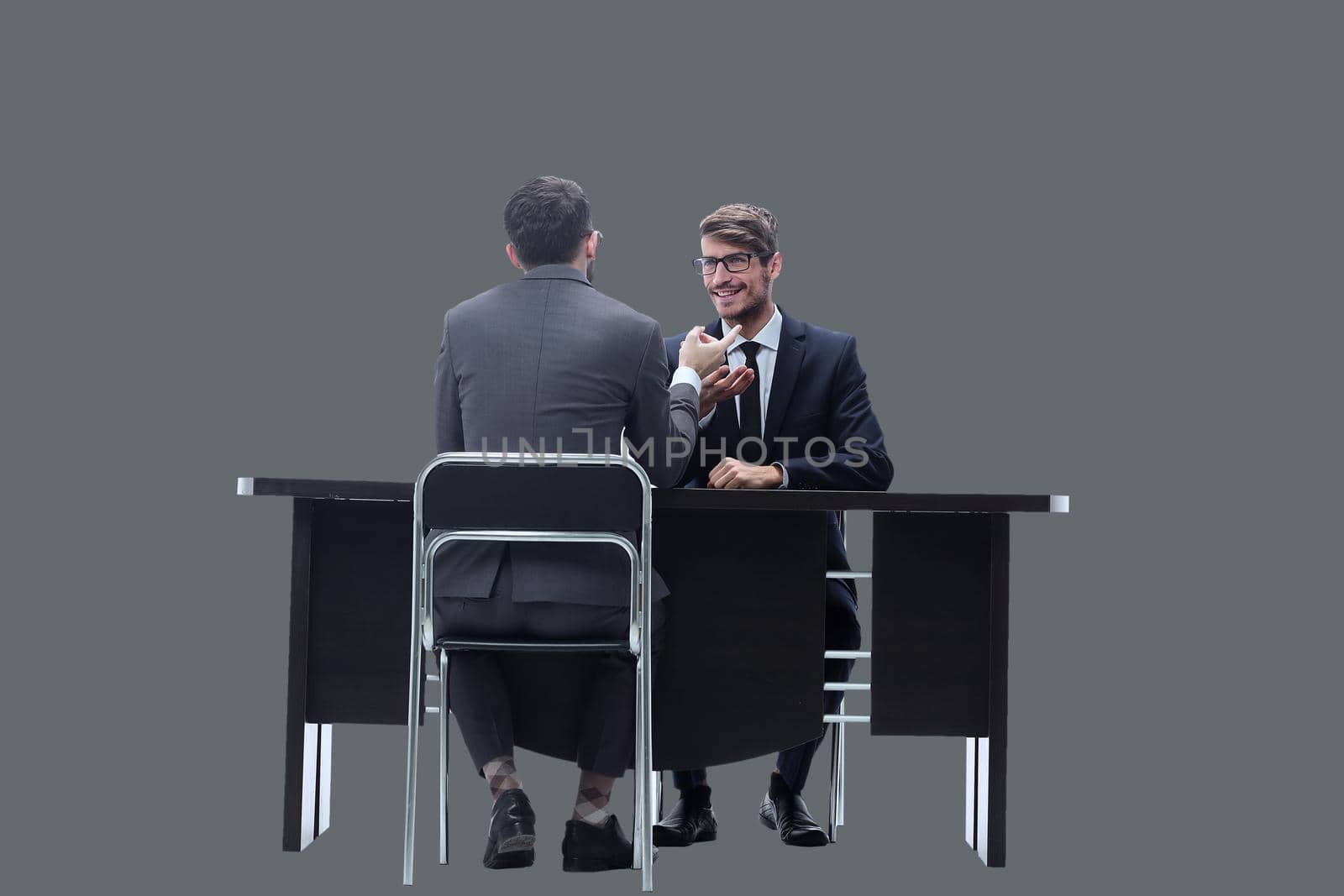 two businessmen talking, sitting at his Desk. isolated on white background