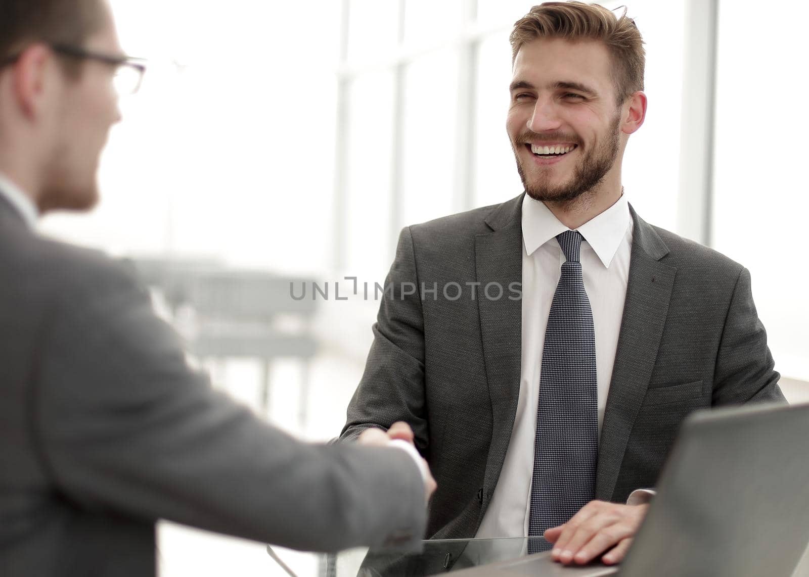 close up.smiling business people shaking hands in office.business concept