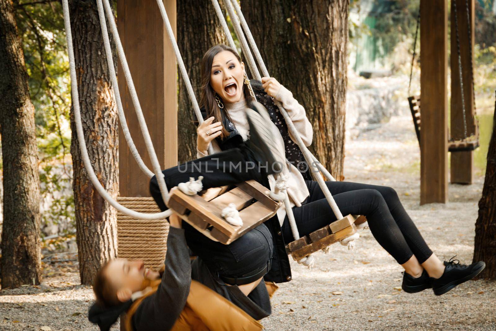 A young man on a date almost fell off a swing in the park. Shocked woman. High quality photo