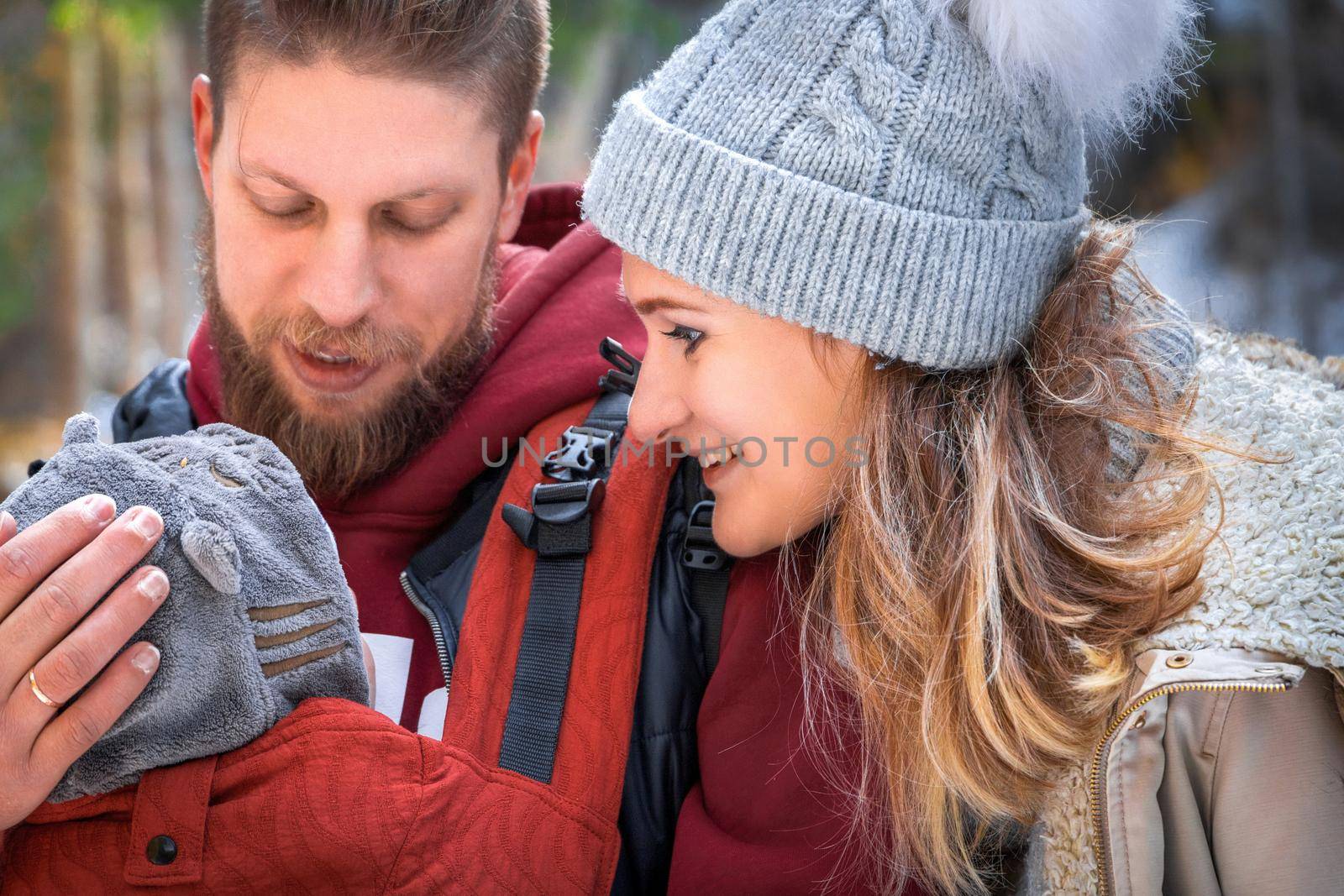 Babywearing winter walk of young parents with their children outdoor.