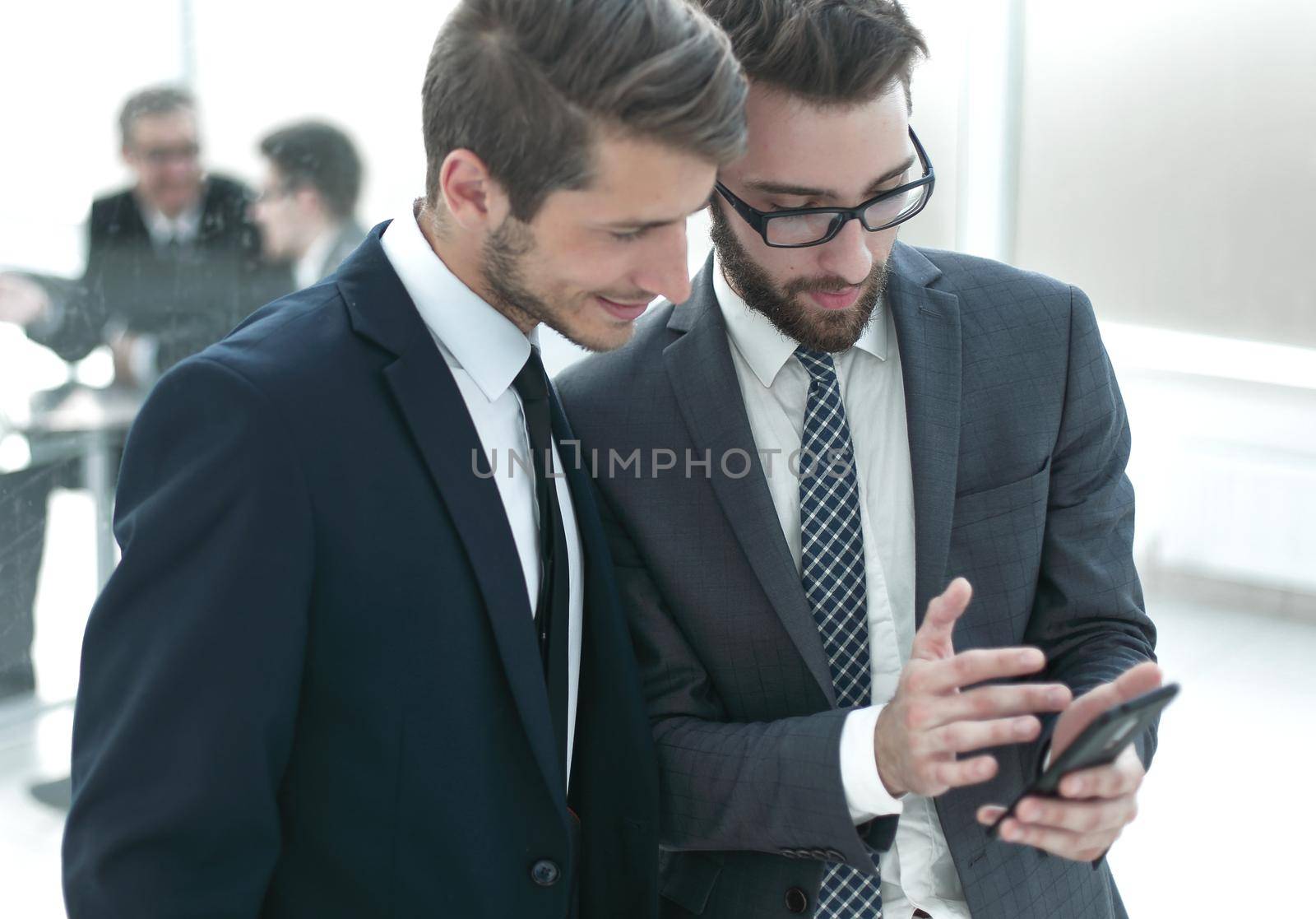 two employees looking at the smartphone screen by asdf