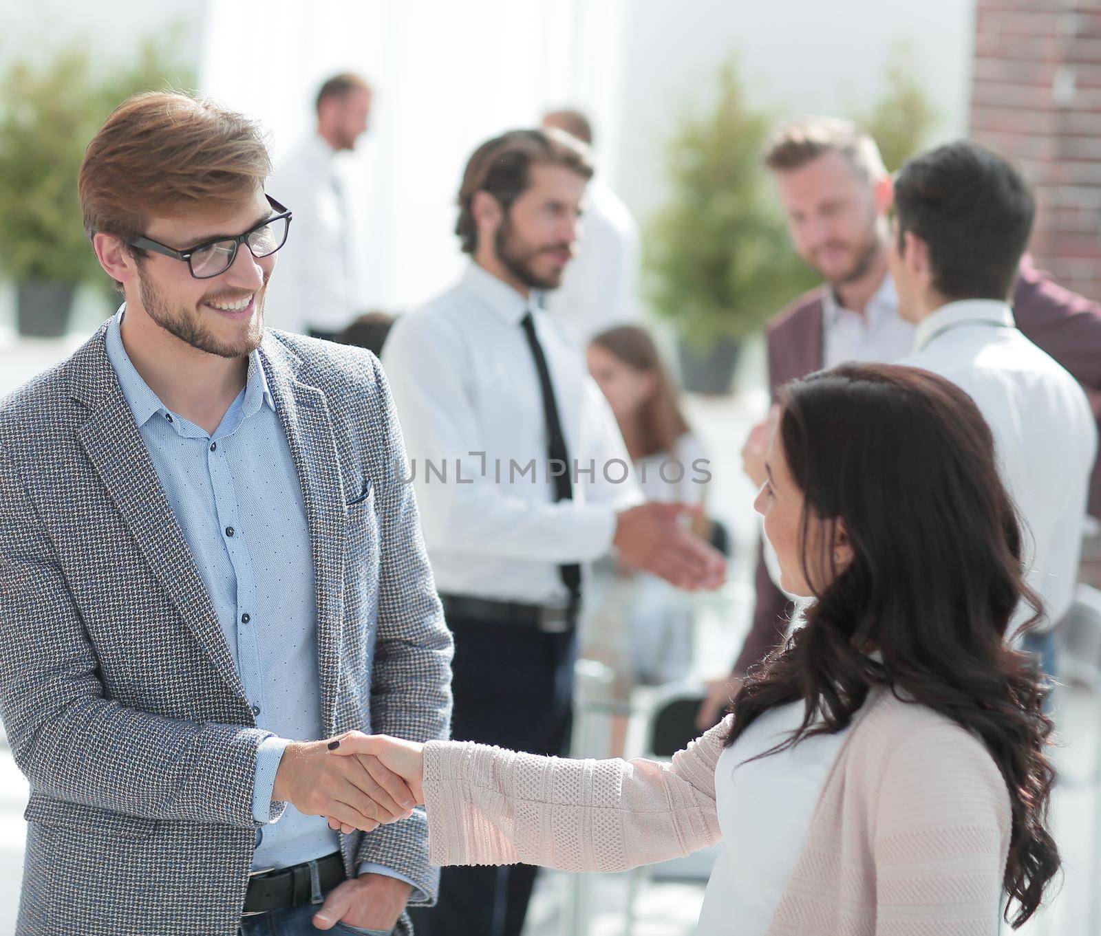 smiling Manager greeting the customer in a modern office. by asdf