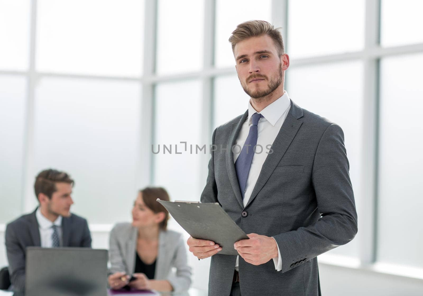 serious businessman with clipboard in the background of office.photo with copy space