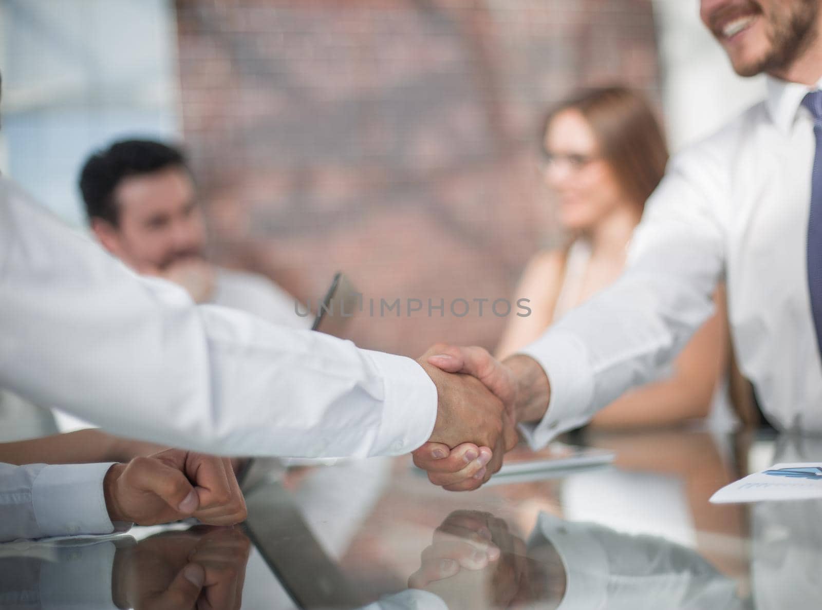handshake of business partners on the background of the desktop. business concept