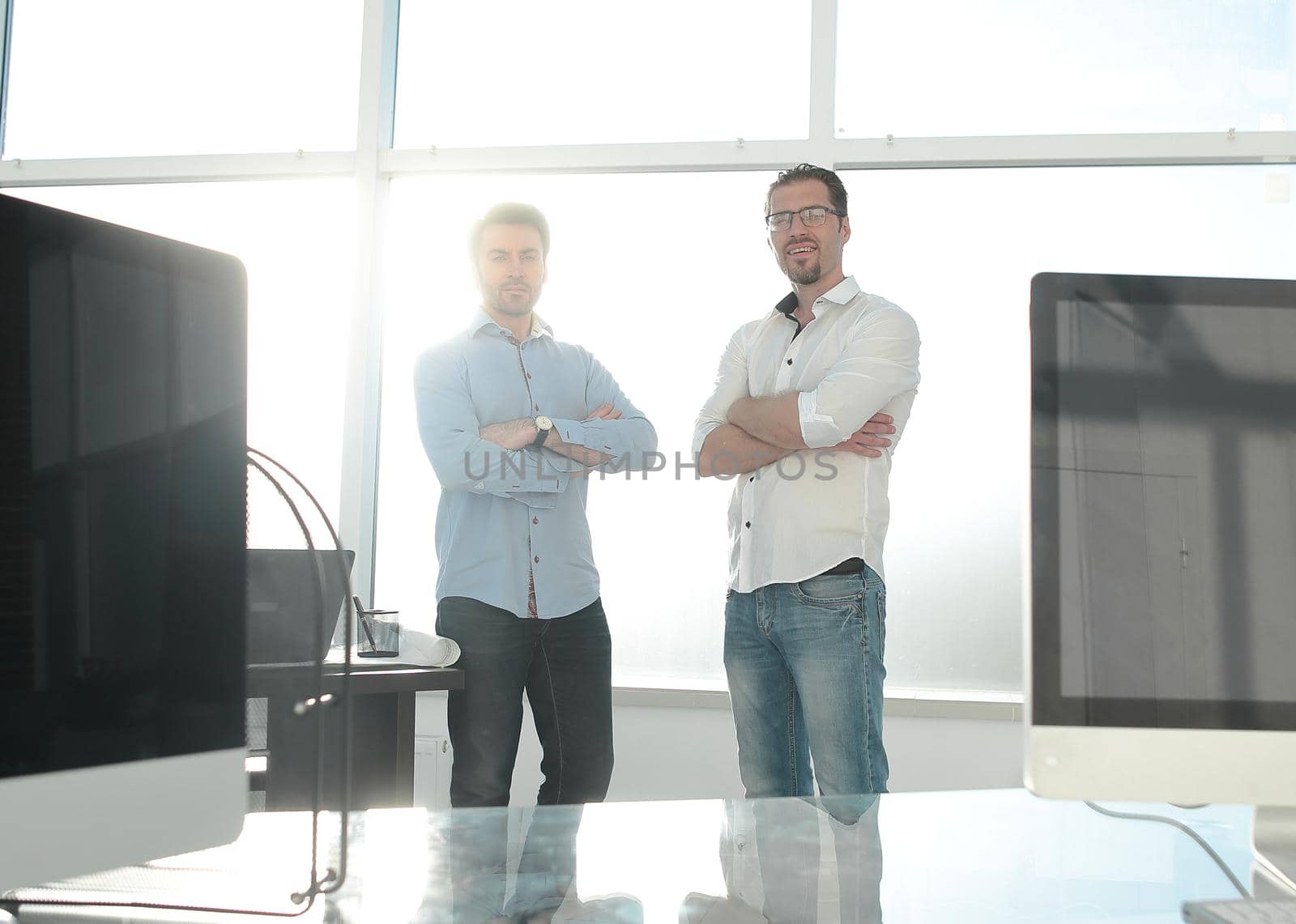 business background.two employees standing in a modern office. by asdf