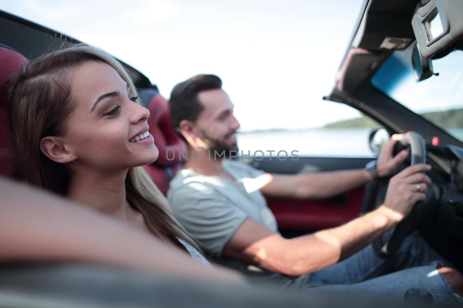 close up.smiling couple sitting in a convertible car.travel together