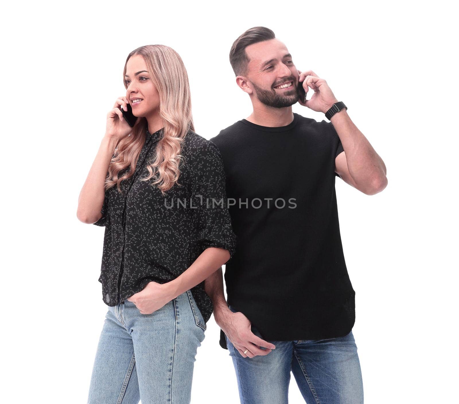 in full growth. young couple talking on their smartphones by asdf