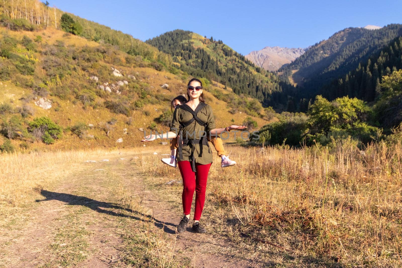 Woman with babywearing baby on a long hike outdoor, hands free.