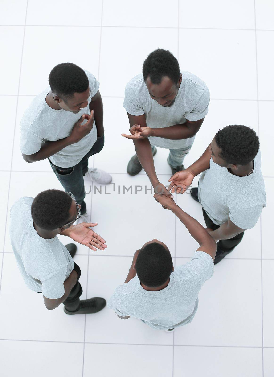 top view. guys shaking hands standing among their friends. isolated on white