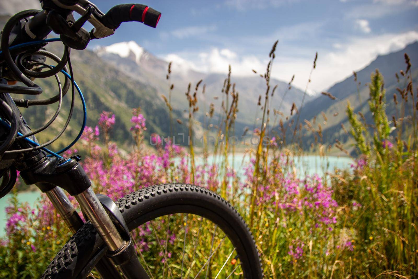 Close-up on the front of a mountain bike on a blurred background of a mountain lake.