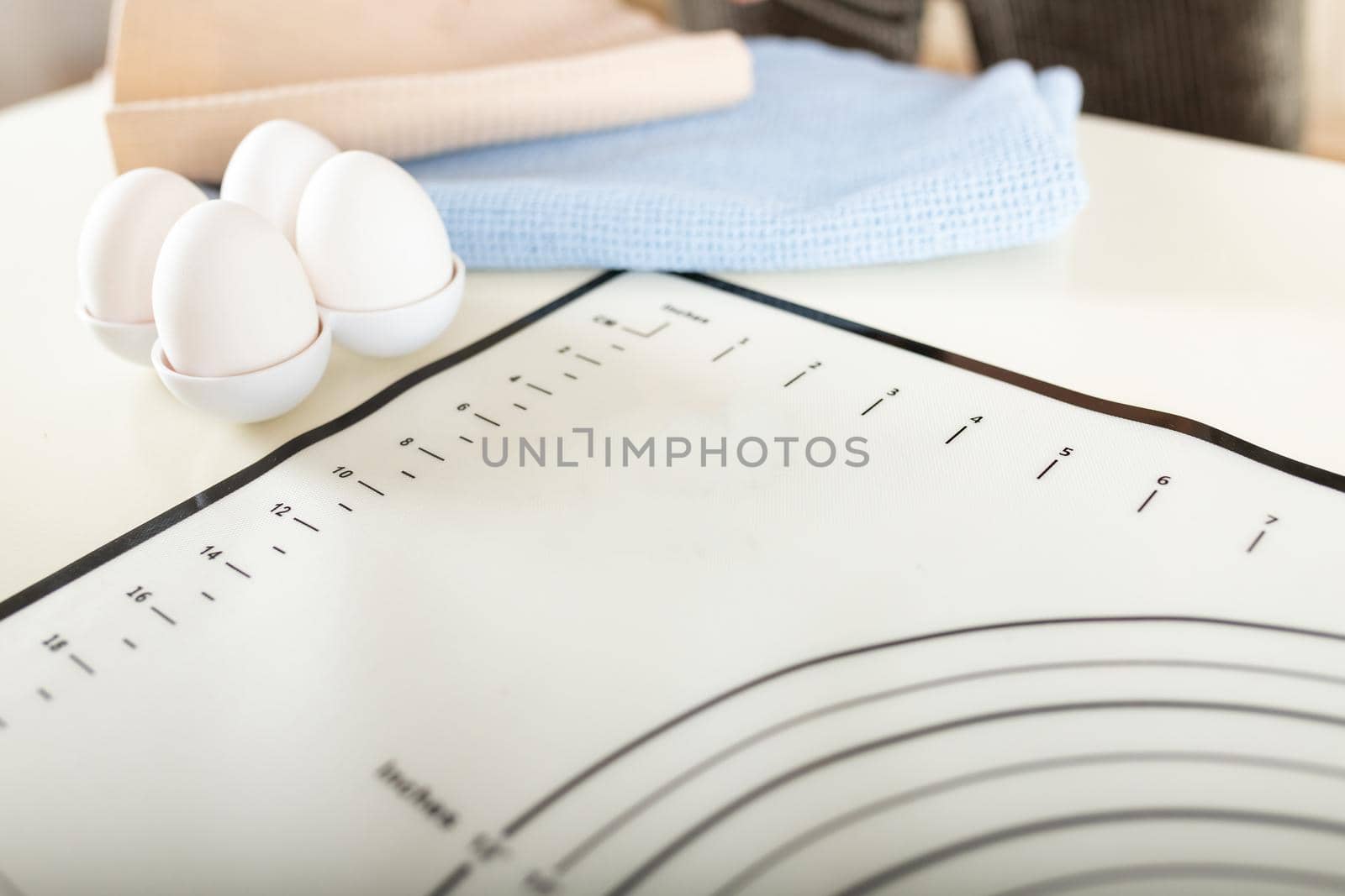 Close-up of eggs, kitchen towels and silicone baking mat on the kitchen table, selective soft focus, copy space.