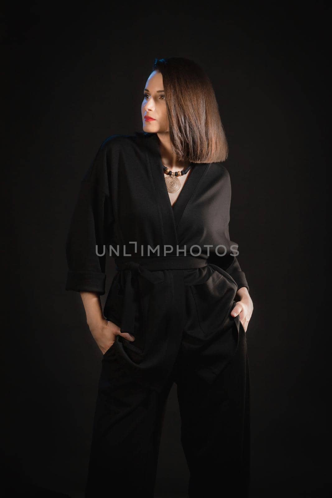 Studio shot of brunette woman 30s wearing black silk pajamas.