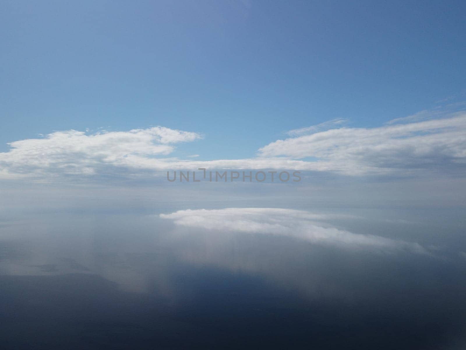 Footage B roll Aerial view drone flying above white clouds dense fog move quickly. Drone flies high back in blue sky through fluffy clouds. Beautiful foggy and cloudy slow moving Aerial view. Fog sea.
