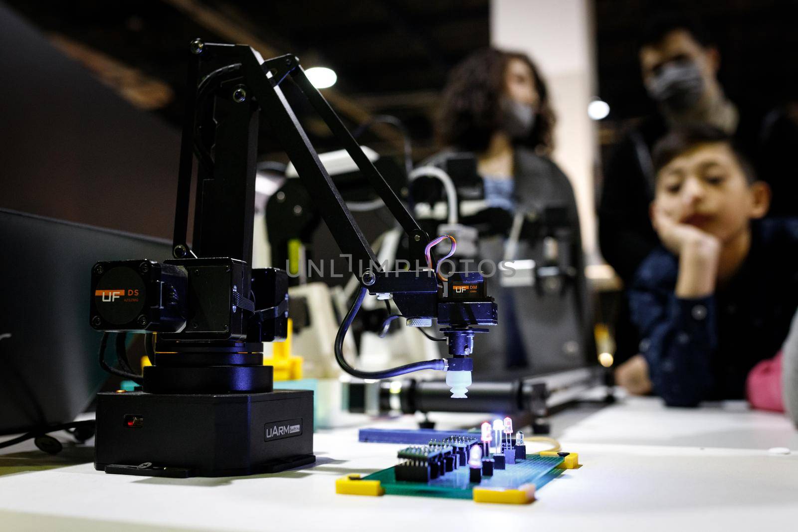 Conveyor-type robot mounting chips at the exhibition stand of the robot festival. Almaty, Kazakhstan - February 19, 2022