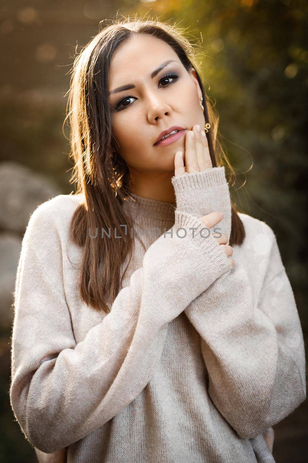 Close-up of a beautiful woman in the forest among the trees at sunset. High quality photo