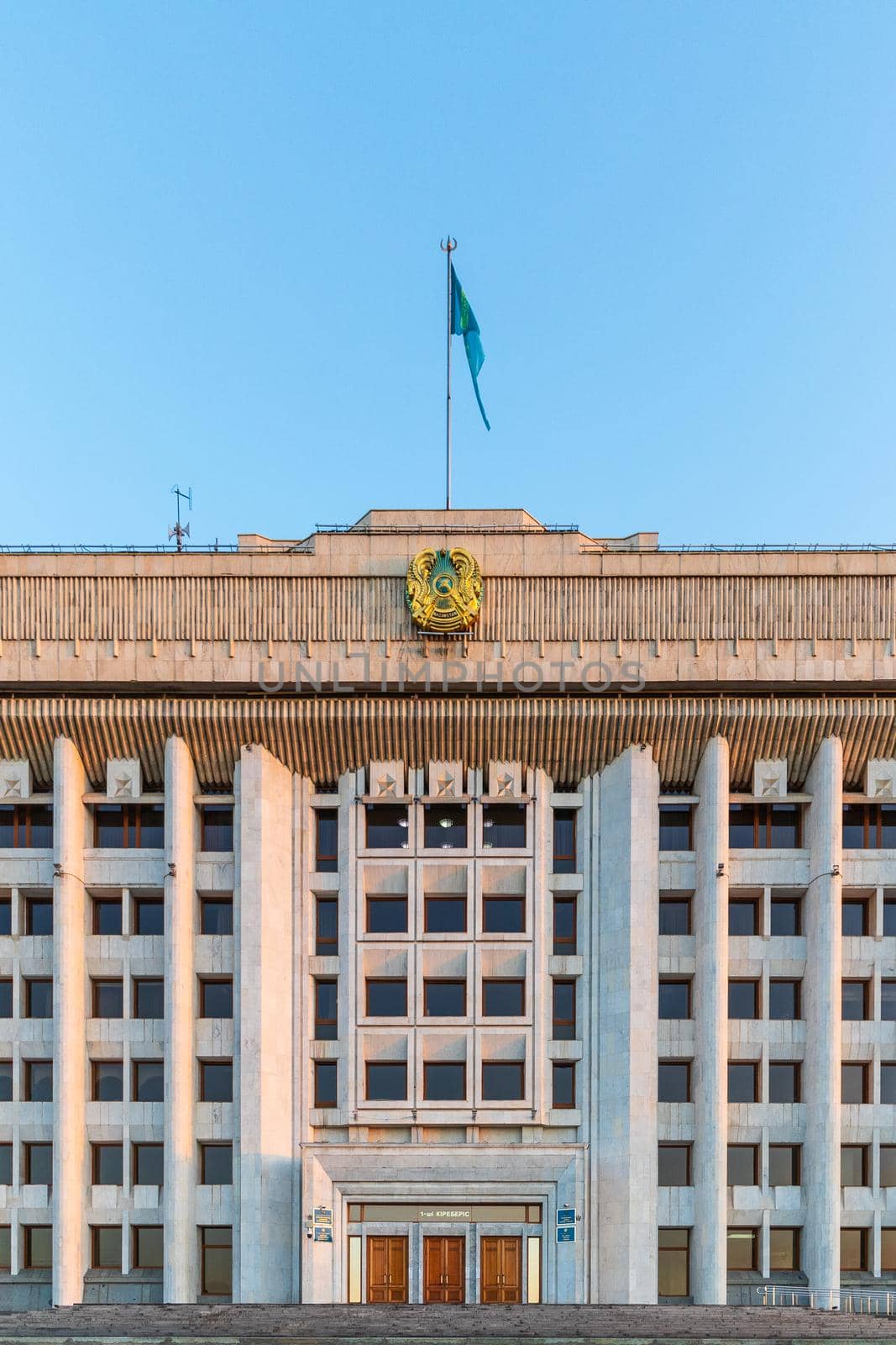 Administration of the city of Almaty with the coat of arms and flag of the Republic of Kazakhstan. Almaty, Kazakhstan - September 05, 2021