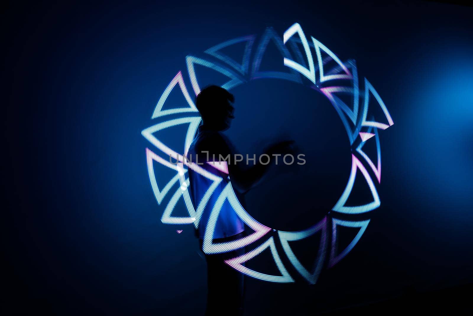 Night Light show of jugglers with LED sticks at the robot exhibition. Almaty, Kazakhstan - February 19, 2022
