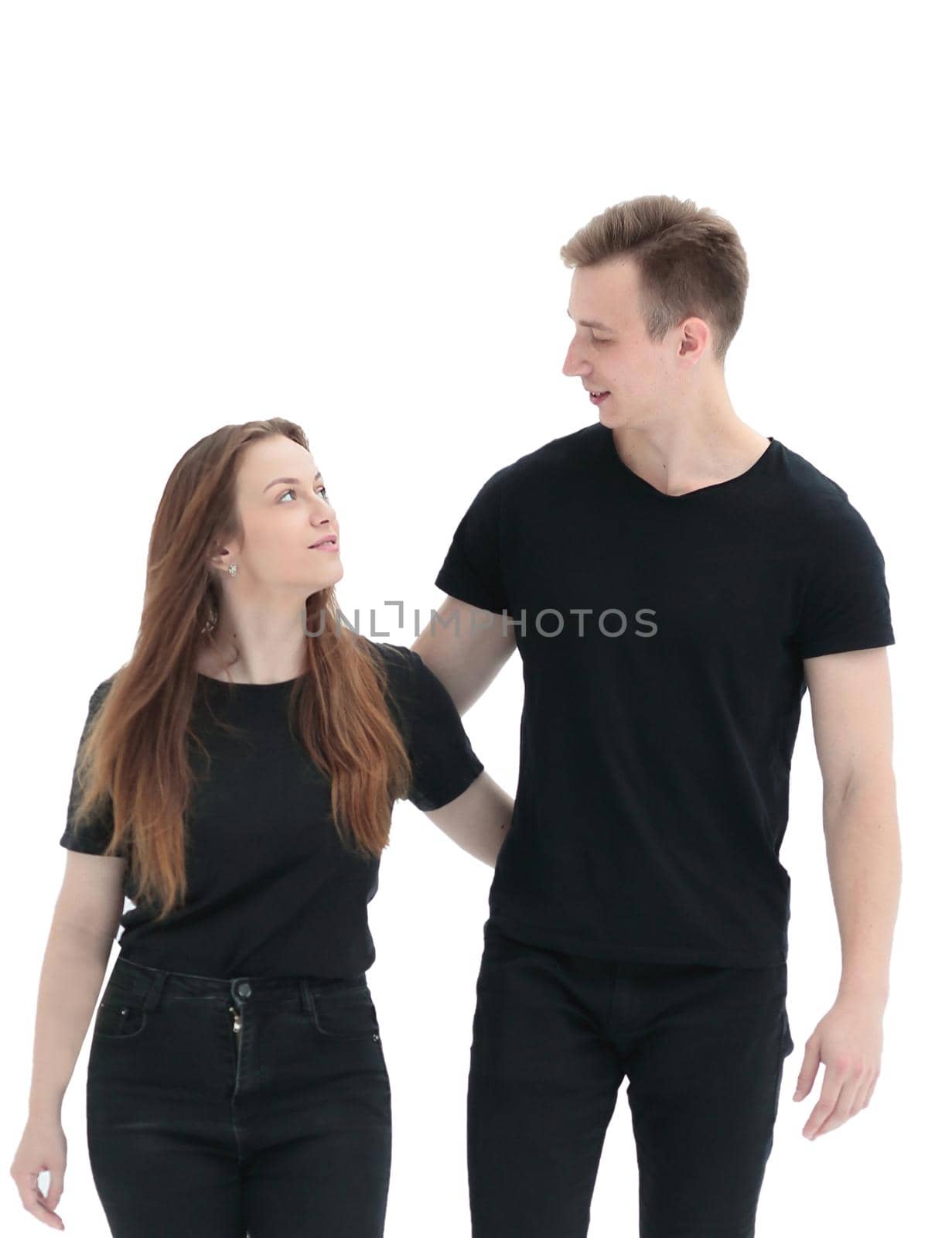 in full growth. casual young couple looking at each other . isolated on white