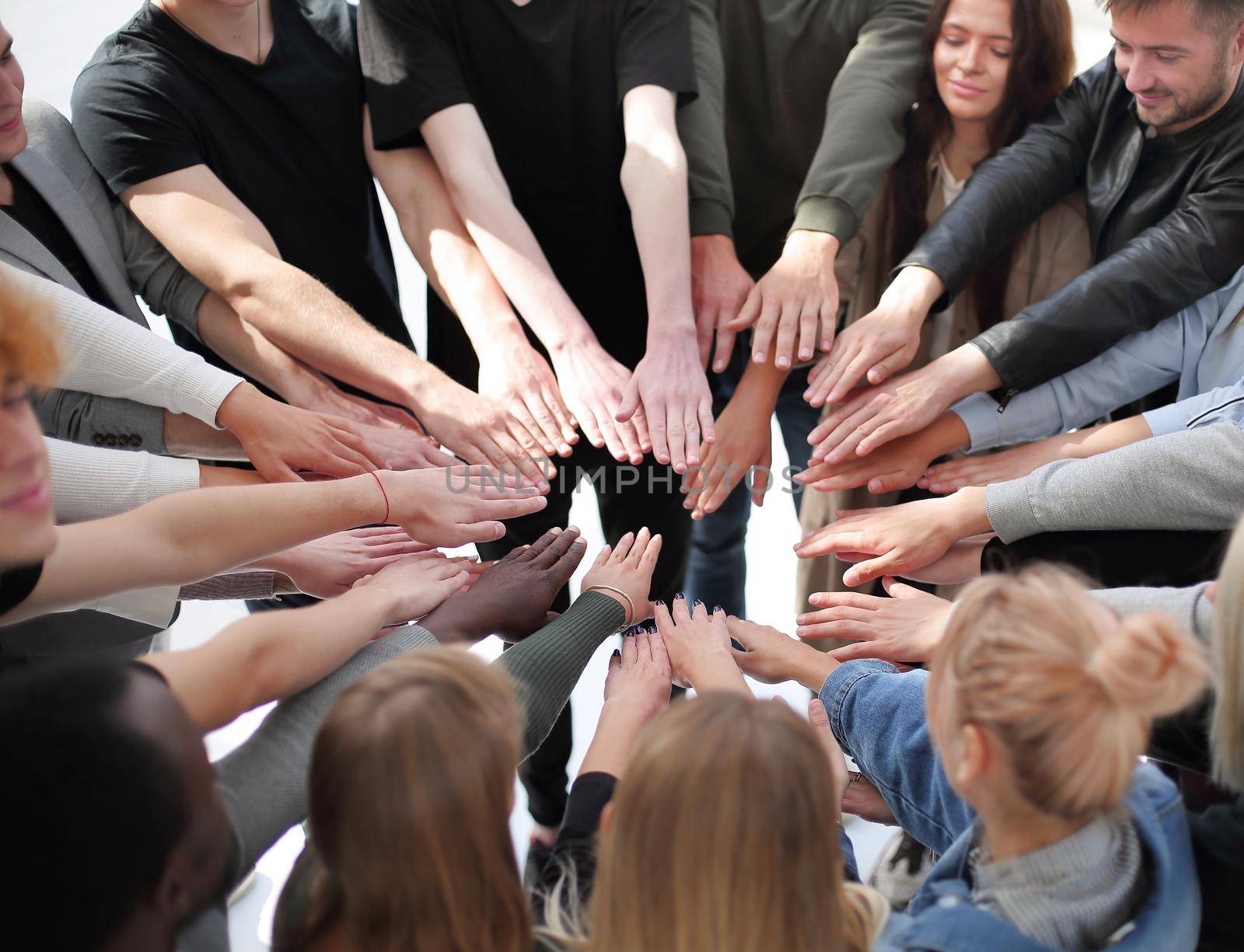 group of diverse people joining their hands in a circle. by asdf