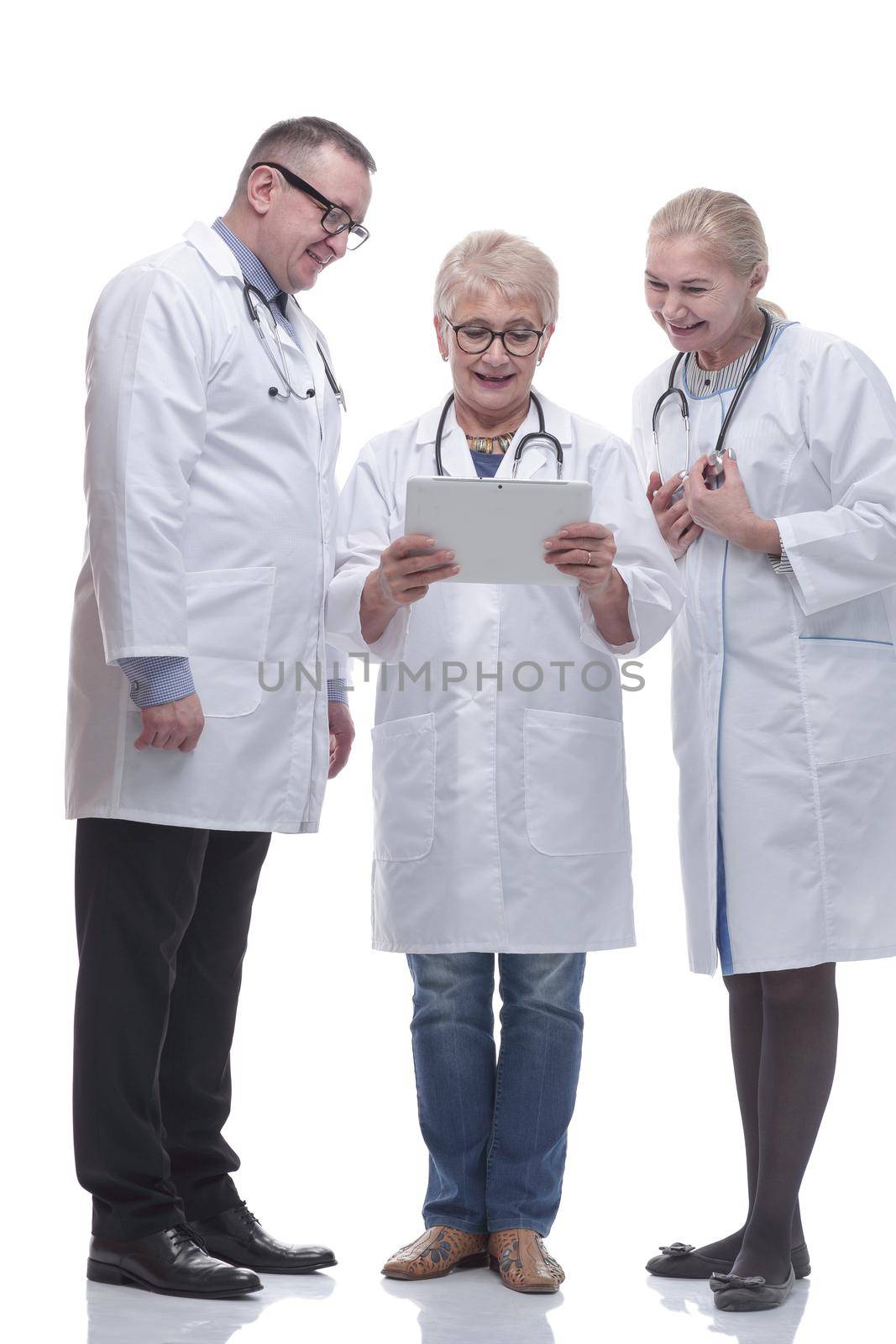 in full growth. group of smiling doctors with a digital tablet. isolated on a white background