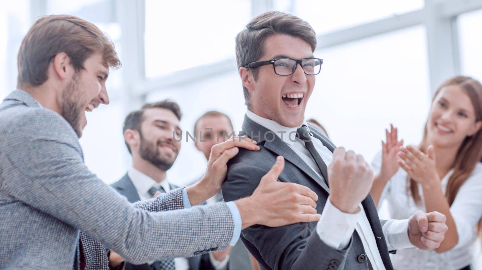 group of cheerful company employees congratulating their colleague by asdf