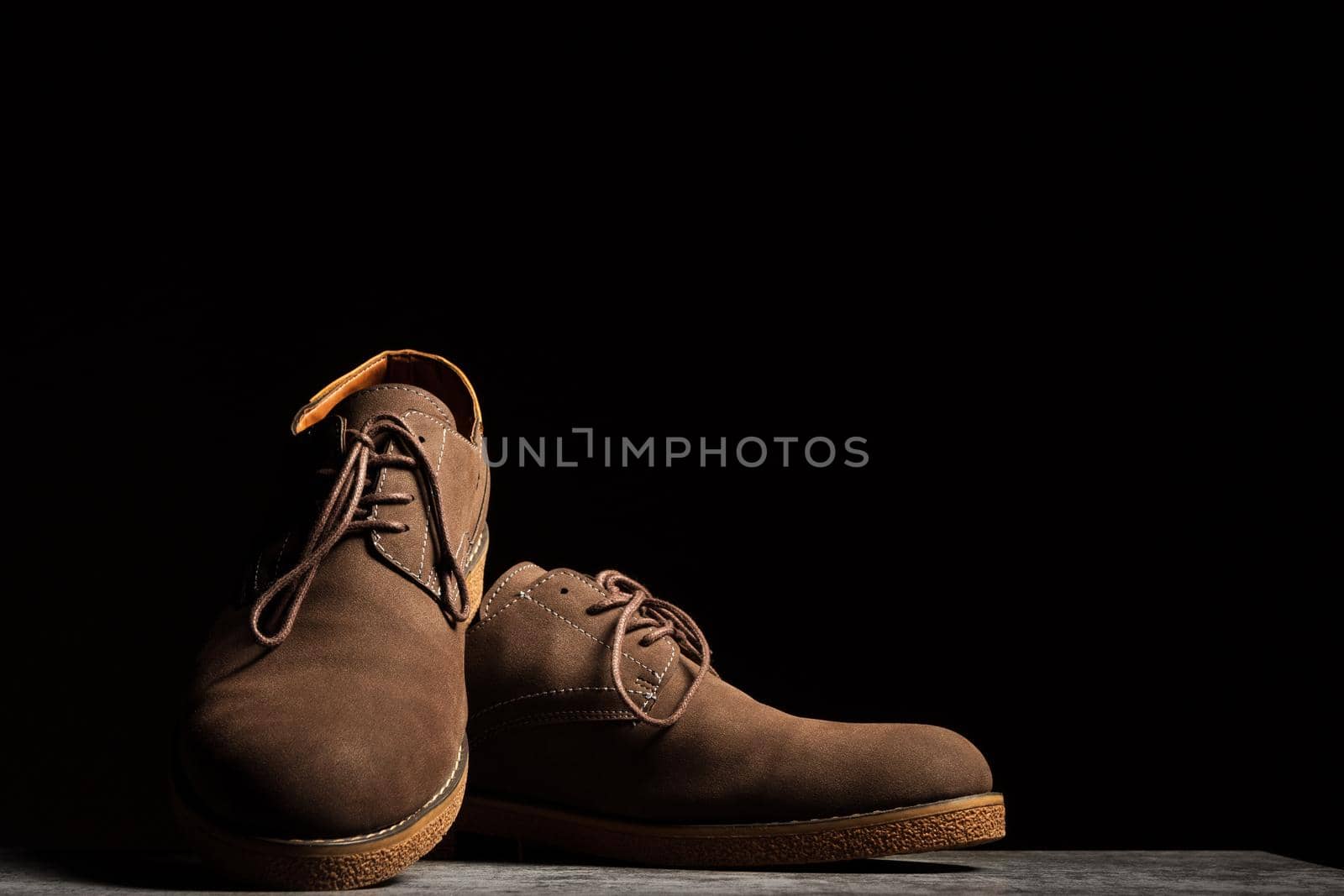 Elegant brown shoes with laces on a black background with copy space