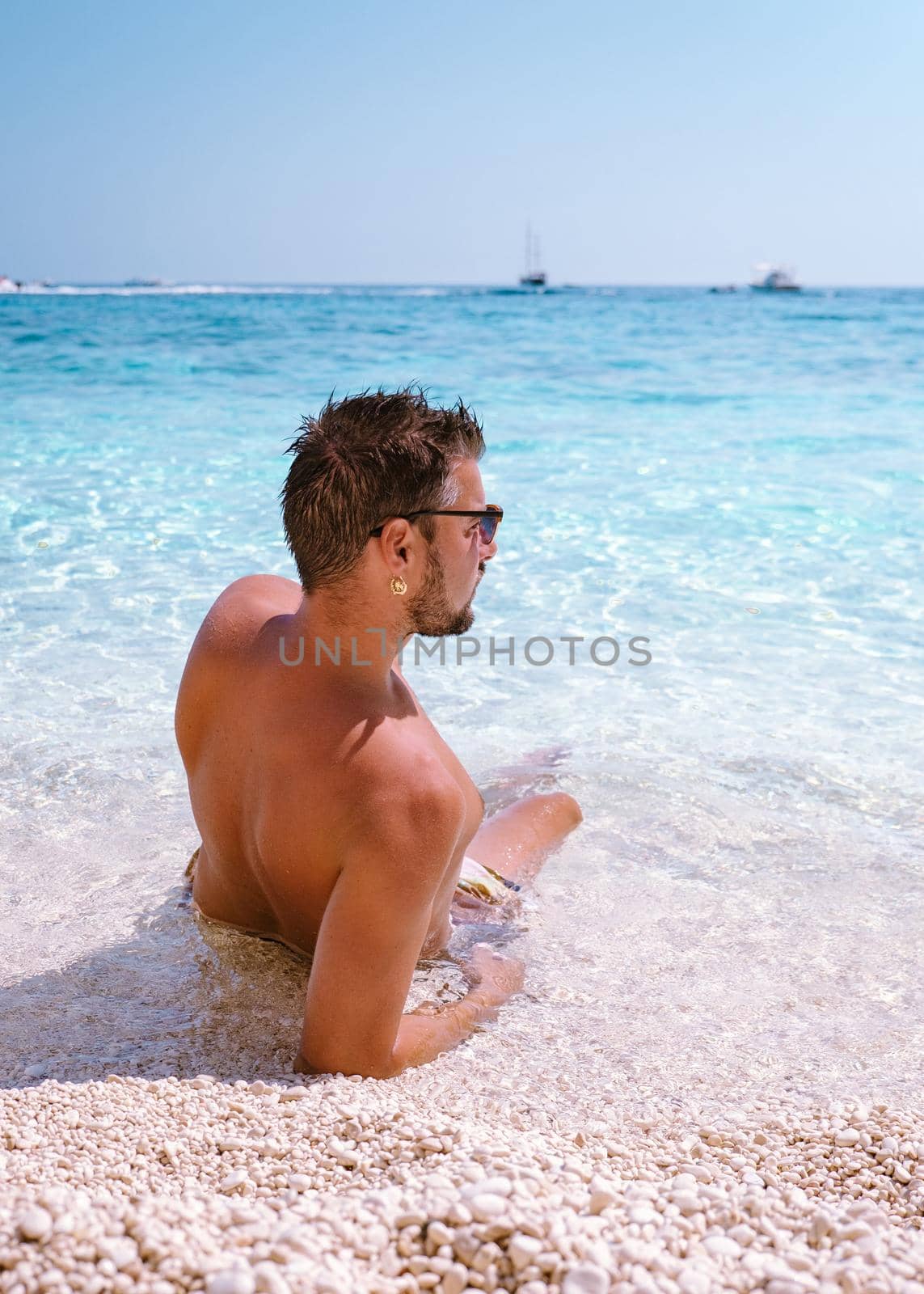 Golfo di Orosei Sardina, Men on the beach Sardinia Italy, young guy on vacation Sardinia Italy, man playing in the ocean with crystal clear blue water, by fokkebok