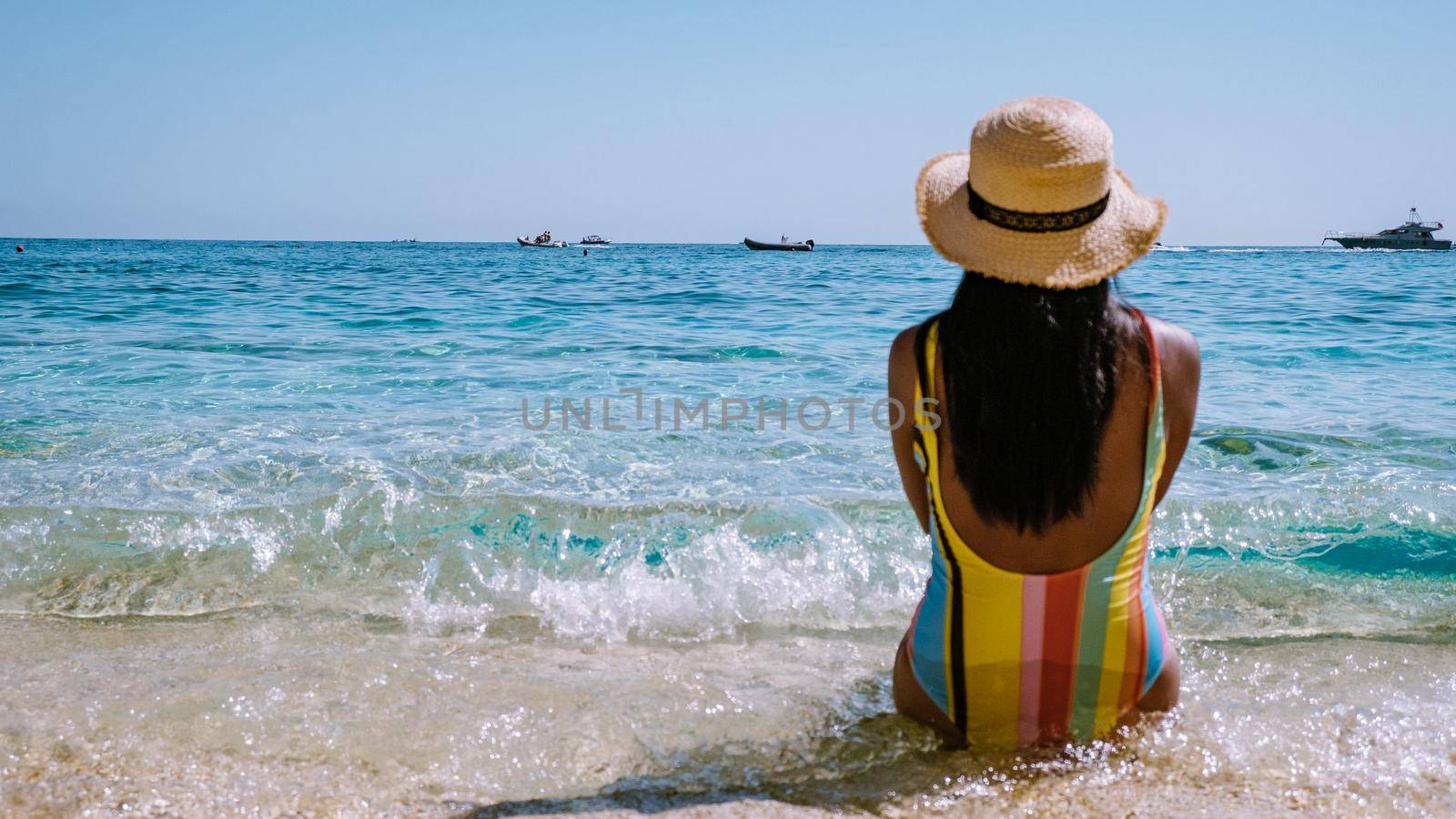 Golfo di Orosei Sardina, Asian women on the beach Sardinia Italy, a young girl on vacation Sardinia Italy, woman playing in the ocean with crystal clear blue water,