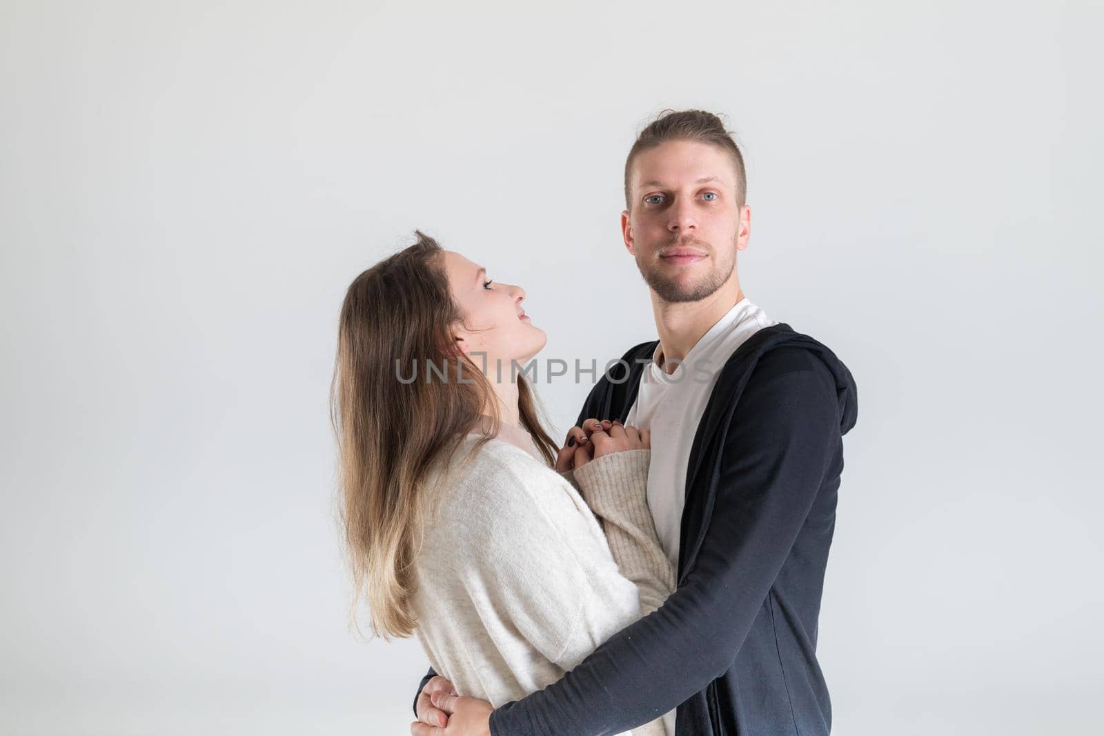 Portrait of a young european couple hugging lovers on a white background.