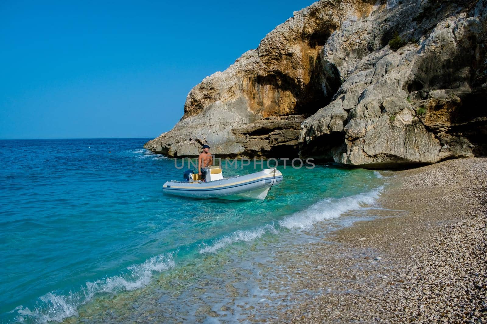 Golfo di Orosei Sardina, Men on the beach chilling in speed boat Sardinia Italy, young guy on vacation Sardinia Italy, man playing in the ocean with crystal clear blue water, by fokkebok